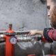 Close-up Of Male Plumber Fixing White Sink Pipe With Adjustable Wrench