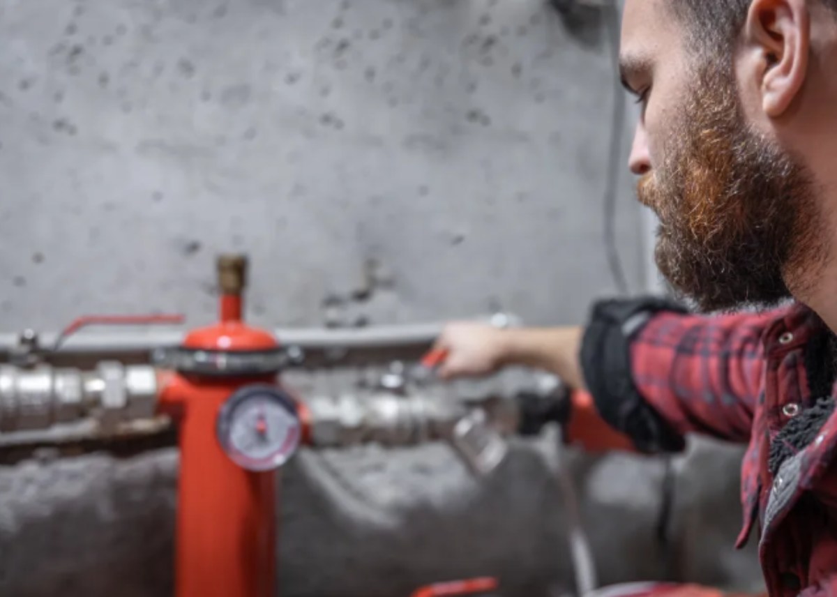 Close-up Of Male Plumber Fixing White Sink Pipe With Adjustable Wrench